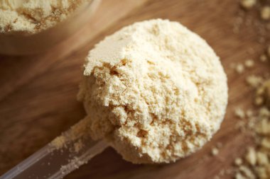 Bir ölçü kaşığında beyaz protein tozu, üst görünüm.