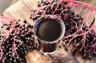 Siyah yaşlı ya da Sambucus nigra şurubu ve masada taze elderberry. Bitkisel ilaçlar.