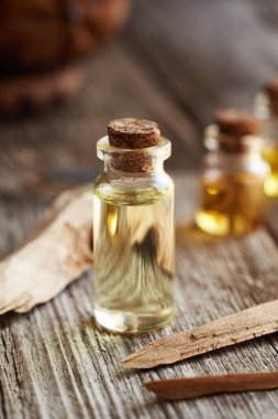 Cam bir şişe aromaterapi. Beyaz sandal ağacı parçalarıyla gerekli yağ.