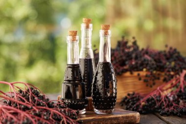 Bahçede taze böğürtlenli siyah yaşlı şurubu şişeleri