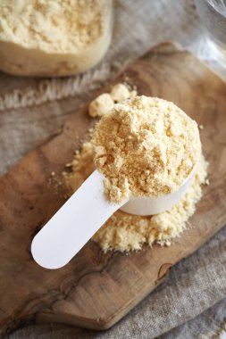 Beyaz plastik bir kaşık içinde beyaz protein tozu