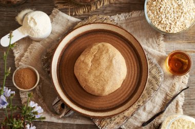 Süt tozu, yulaf ezmesi, akçaağaç şurubu, vanilya ve fıstık ezmesinden yapılmış hamur topu - ev yapımı protein barlarının hazırlanması