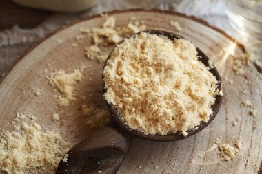 Masadaki tahta kaşıkta kurutulmuş beyaz protein tozu.