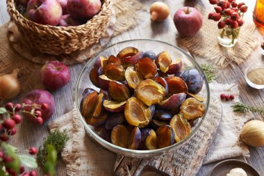 Bir kase taze erik, elma, soğan ve kekik. Ev yapımı acı sos ya da çeşni için malzemeler.             