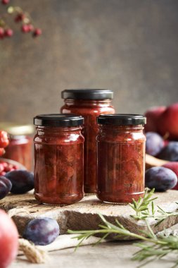 Üç cam kavanozda ev yapımı acı sos. Erik, elma, soğan ve baharattan yapılmış çeşni.