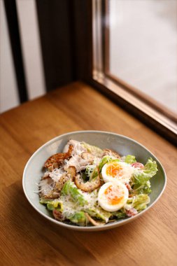 Yumurtalı, tavuklu, peynirli, yeşil marullu, peynirli klasik Sezar salatası.