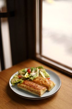 Tavuklu kızarmış gözleme ve yeşil salata, salatalık, domates ve kabak çekirdeği.