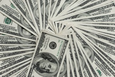 Eski usul yüz dolarlık banknotların temiz bir hayranı beyaz bir masada yatıyor.