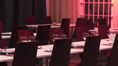 Zarif sofra takımları ve parlayan kırmızı ışıklarla dolu boş bir restoranda güzel bir şekilde hazırlanmış tatil masaları, sıcak, şenlikli, davetkar bir ortam yaratıyor. Kutlamalar ya da özel etkinlikler için mükemmel. 
