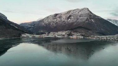Norveç 'te karlı bir fiyort, görkemli dağlarla ve huzurlu bir köyle çevrili. İnsansız hava aracı tarafından yakalanan, sergilenen kışlar sakin güzellik. 