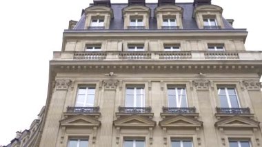 Paris, Fransa 12.21.2024. Paris 'teki tarihi Bourse de Commerce yakınlarında modern eğimli bir cephede duran turistler, çağdaş ve klasik tasarımı birleştiriyor.. 