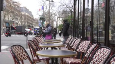 Paris, Fransa 12.21.2024 Boş kafe masaları kışın hareketli bir Paris caddesi, cazibe, kentsel enerji ve mevsimsel atmosfer karışımı çağrıştırıyor. 