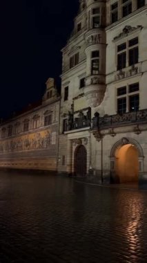 Almanya, Dresden 'de güzel aydınlatılmış tarihi bir bina cephesi. Karmaşık mimari ve gece manzarası sergileniyor.. 