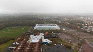 Amiens, Fransa 'da modern bir stadyum, eğitim alanları, park alanları ve yakınlardaki yerleşim alanlarının yer aldığı bir spor kompleksinin havadan görünüşü. Kentsel ve kırsal ortamların karışımı.