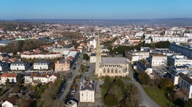 Epernay, Fransa 'nın havadan görünüşü, açık bir gökyüzü altında tarihi bir kiliseyi, kentsel sokakları, konut binalarını ve manzaralı kırları vurguluyor.. 