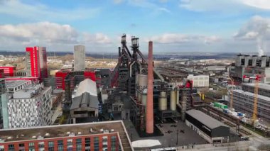 Lüksemburg 'un Esch-sur-Alzette kentsel dönüşümünü ve endüstriyel mirası ön plana çıkaran, modern mimariyle çevrili tarihi bir patlama fırınının yer aldığı hava manzarası.. 