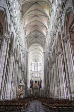 Fransa 'nın iç katedralinde yüksek Gotik kemerler, kubbeli tavanlar, ayrıntılı bir sunak ve sakin bir ortamda sıra sıra tahta sandalyeler yer alıyor. Amiens. Fransa 17.02.2025