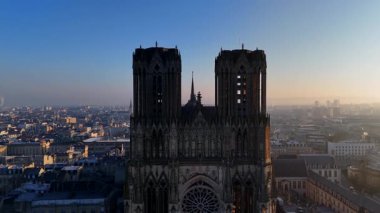 Reims Katedralleri 'nin çarpıcı drone görüntüsü arka planda şehir ile karışık gotik cephe, şafak vakti doğan güneşin sıcacık parıltısıyla yıkanmış. 