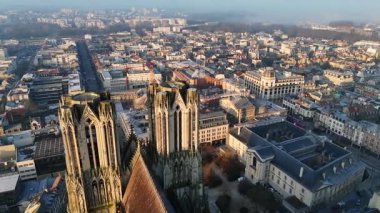 Şafak vakti Reims Katedrali 'nin kuleleri üzerinde uçan nefes kesici bir hava manzarası, arka planda uyanış şehri olan gotik mimarisini yakalıyor.. 