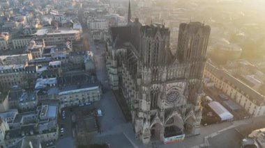 Güneşin doğuşunda Reims Katedrali 'nin karmaşık Gotik cephesinde altın ışığın tarihi mimarisini vurguladığı nefes kesici bir hava manzarası.. 