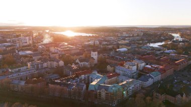Günbatımında İsveç 'in Karlstad kentinin çarpıcı hava manzarası. Tarihi mimari, kilise kulesi ve nehre yansıyan altın ışık..