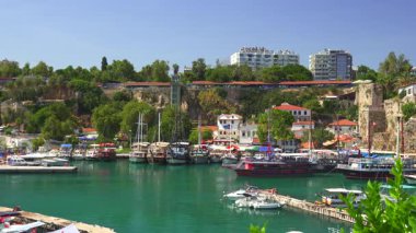 Antalya, Türkiye 11.02.2024 Antalya Eski Kent yat limanının turkuaz sular, renkli tekneler, yemyeşil alanlar, tarihi binalar ve canlı bir kıyı atmosferinin manzarası.