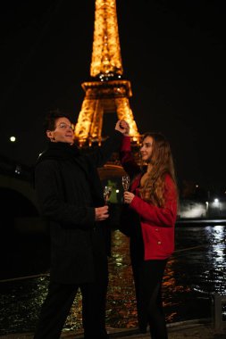 Neşeli bir çift, aydınlanmış Eyfel Kulesi 'nin altında aşk, mutluluk ve Paris' in sihrini kutlarken romantik bir dans eder.. 