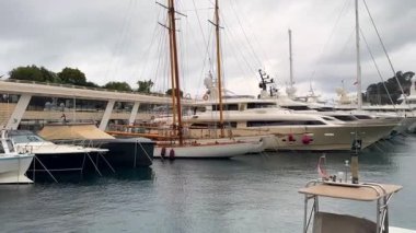 03.18.2025 Monaco, Fransa sakin sularda demirlemiş lüks yatlar ve bulutlu gökyüzü altında yemyeşil yemyeşil yemyeşil bir yer.