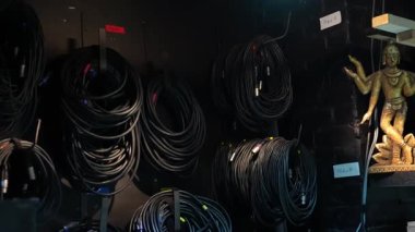 Sahne arkası duvarına düzgünce yerleştirilmiş çeşitli siyah bobinli kablolar, sahne ışıkları, ses ve profesyonel tiyatro veya konser ayarları için kullanılır..