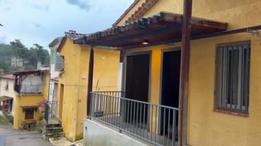 Fransa 'nın bir Avrupa köyü Contes' te pitoresk dar bir cadde. Ahşap panjurları ve terracotta çatıları olan kırsal sarı ve pastel renkli binalarla dolu. Huzurlu atmosfer