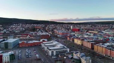 Gün batımında İsveç 'in Sundsvall kentinin havadan görünüşü, manzaralı rıhtım, merkez tren istasyonu, sanayi bölgesi ve sıcak, ışıl ışıl parlayan gökyüzü altındaki konut binaları.. 