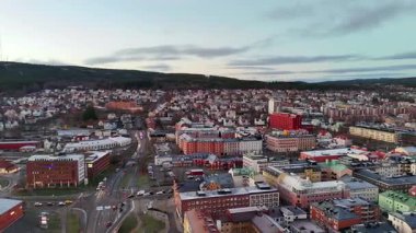 Gündoğumunda İsveç 'in Sundsvall kentinin havadan görünüşü, tarihi binalar, sakin bir nehir, modern bir köprü ve huzur dolu su yüzeyine güzel bir şekilde yansıyan altın bir gökyüzü..