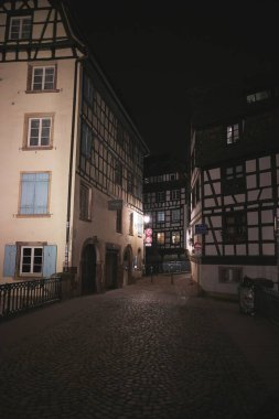 Strasbourg Petite France dar bir sokak sessiz gece manzarası, yarım kereste evler ve yumuşak sokak ışıklandırması