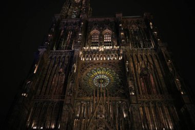 Strasbourg Katedrali 'nin dramatik gece manzarası. Karmaşık Gotik mimarisini ve parıldayan vitray gül penceresini gözler önüne seriyor..