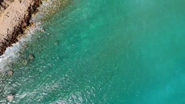 Antalya Türkiye 10.23.2024 yüksek çözünürlüklü yüksek çözünürlüklü, kayalık plajlı, ağaçlarla çevrili bir kıyı şeridi ve uzak tepelerle çevrili bir turkuaz hanenin fotoğrafı. Açık mavi gökyüzü ve doğal bir sakinlik 