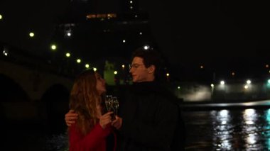 Romantik bir çift şampanya bardakları tutar ve parıldayan Eyfel Kulesi 'nin altında gülümserler. Paris' te büyülü bir anın tadını çıkarırlar..