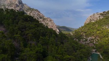 Kayalık uçurumlar, yoğun yeşil ormanlar ve vadide kıvrılan berrak su nehri ile Türk kanyonunun 360 derecelik görüntüsü. 