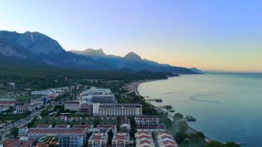 Antalya kıyı şeridinin havadan görünüşü. Huzurlu sabahlar boyunca sahil otelleri, ormanlı tepeler ve görkemli dağların yer aldığı yer..