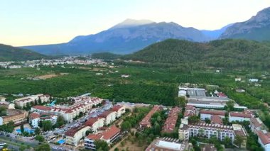 Antalya 'daki renkli deniz manzaralı oteller, rıhtımlar ve sakin körfez yeşil tepeler ve kıyı ufuk çizgisinin üzerinde yumuşak sabah güneşiyle. 
