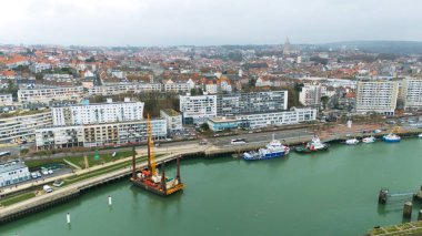 Boulogne. Fransa 03.28.2025 Boulogne-sur-Mer rıhtımının havadan çekilmiş fotoğrafı su platformunda, rıhtımda ve şehrin arkasında bir inşaat vincini gösteriyor.. 