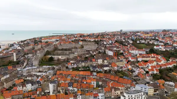 Boulogne. Fransa 03.28.2025 Yoğun bir kıyı kasabasının kırmızı kiremitli çatıları, orta çağ konut blokları ve bulutlu gökyüzünün altında manzaralı bir kıyı şeridi. 