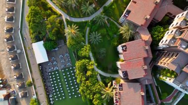 Sakin bir deniz, havuzlar, dinlenme yerleri ve sakin sahil manzaralı lüks bir sahil beldesi yakınlarındaki ılık günbatımını yansıtır..