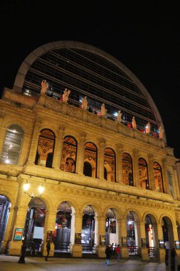Lyon. Fransa 04.20.2025. Gece manzaralı kemerli pencereleri, klasik heykelleri ve modern cam kubbesi olan büyük bir opera binası..