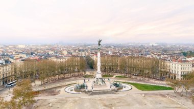 Place des Quinconces Bordeaux Fransa 'daki Girondins Anıtı' nın gündoğumunda pastel gökyüzü ve çevresindeki tarihi mimariyle hava görüntüsü. 