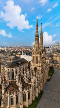 Bordeaux Fransa 'daki Saint Andre Katedrali' nin dikey görüntüsü Gotik kuleleri ve parlak mavi gökyüzüne karşı çatıları gösteriyor.