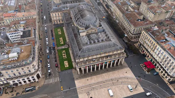 Büyük Bordeaux Tiyatrosu 'nun insansız hava aracı görüntüsü klasik mimariyi, tramvay raylarını ve bulutlu gökyüzünün altındaki yakın kafeleri gösteriyor.