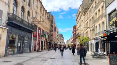 Caen, Fransa 04.01.2025 Canlı yaya bölgesi güneşli bir günde açık hava kafeleri ve tarihi mimari arasında yürüyen insanlar. 