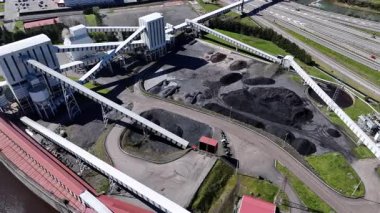 Kömür işleme tesisinin hava aracı görüntüsü. Endüstriyel bölgede büyük taşıyıcılar, kömür yığınları ve bitişik nehir kanalları..