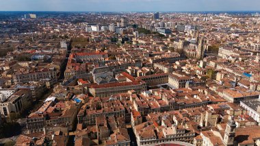 Bordeaux şehrinin insansız hava aracı görüntüsü tarihi çatılar, modern binalar ve güneşli bir şehir manzarasındaki katedrali gösteriyor..