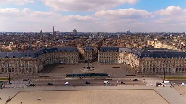 Place de la Bourse 'un insansız hava aracı görüntüsü tarihi binalar, çeşme, tramvay ve güneşli bir gökyüzü altında Bordeaux Fransa' da geniş şehir silueti..